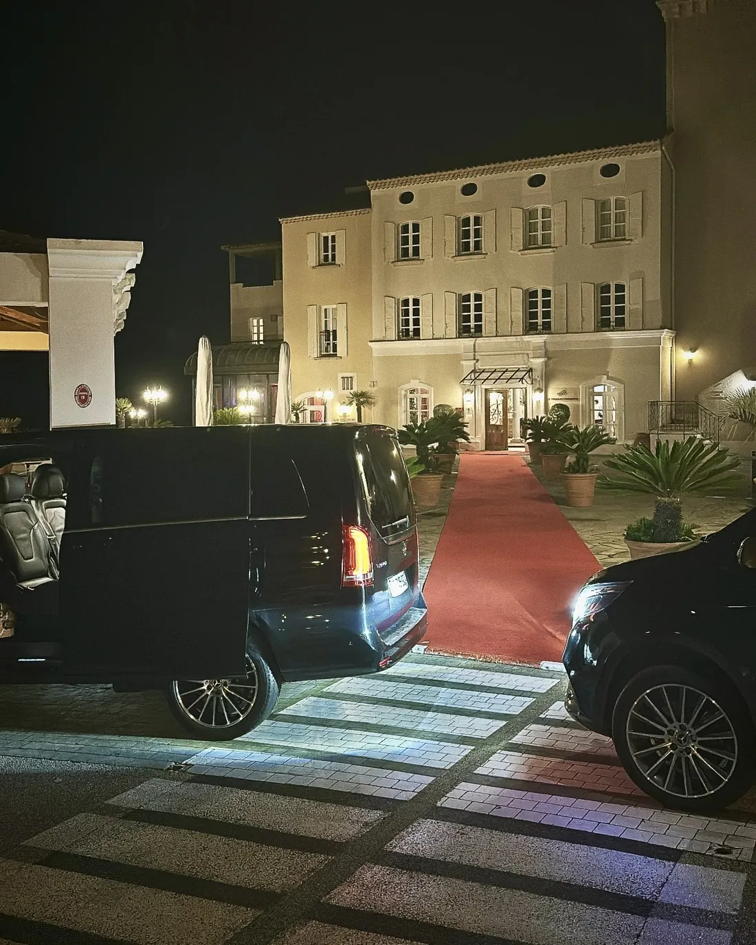 Mercedes Classe V Prestige VTC devant l'entrée d'un hôtel, de nuit