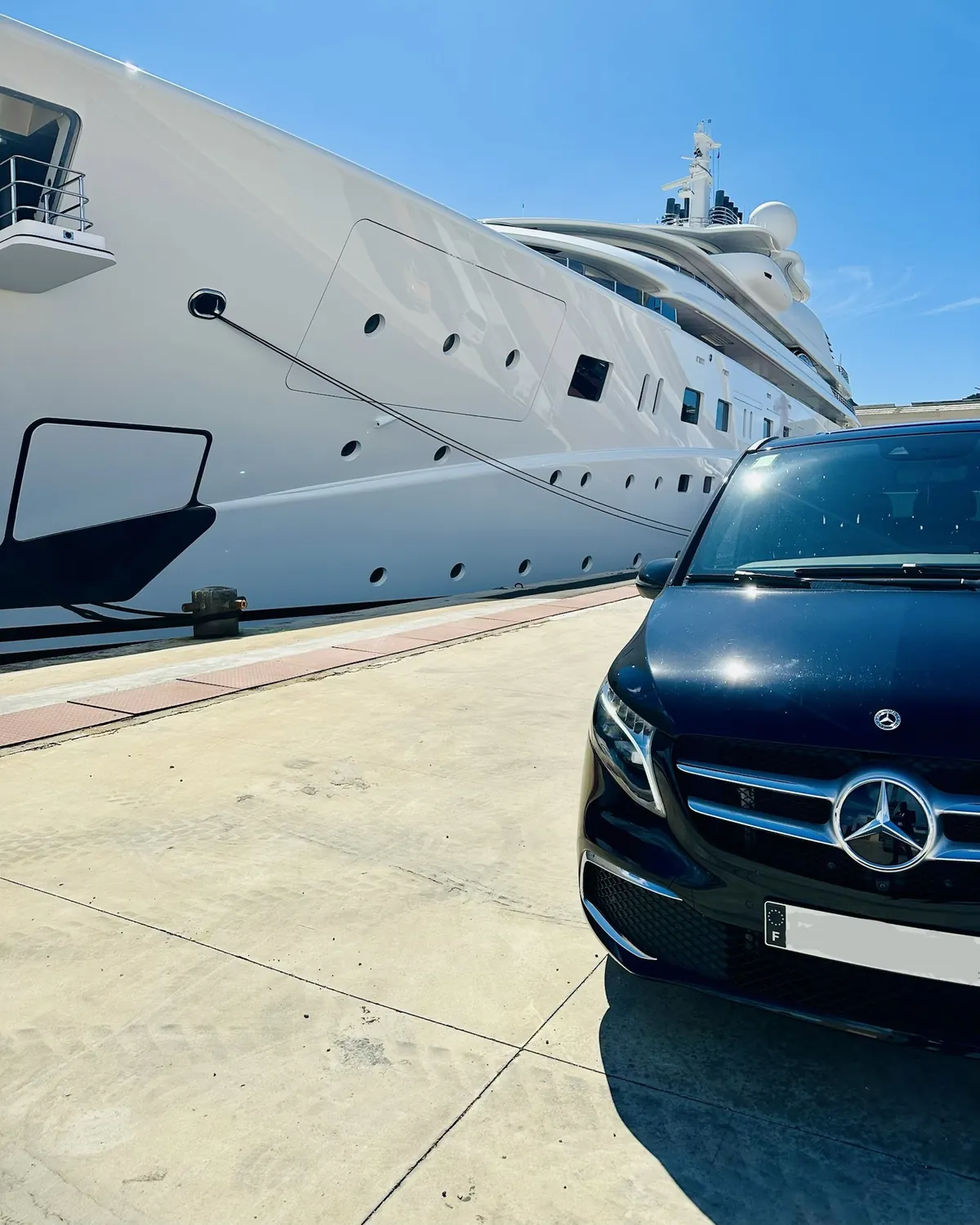 Mercedes Classe V Prestige VTC sur le quai devant un grand yacht