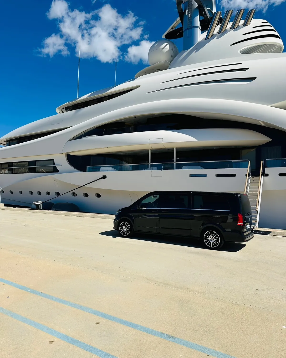 Chauffeur yachting : Mercedes Classe V Prestige VTC sur le quai devant un superyacht