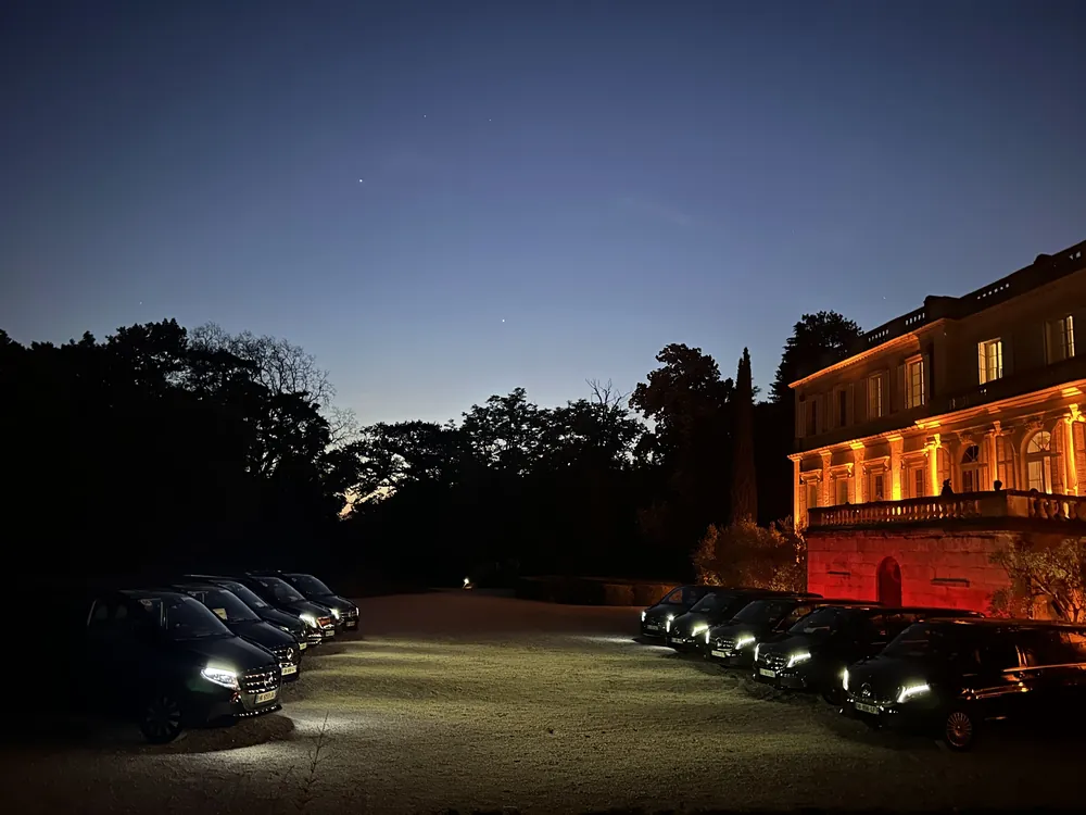 Logistique du transport congrès et salons professionnels : file de Mercedes devant un palais illuminé